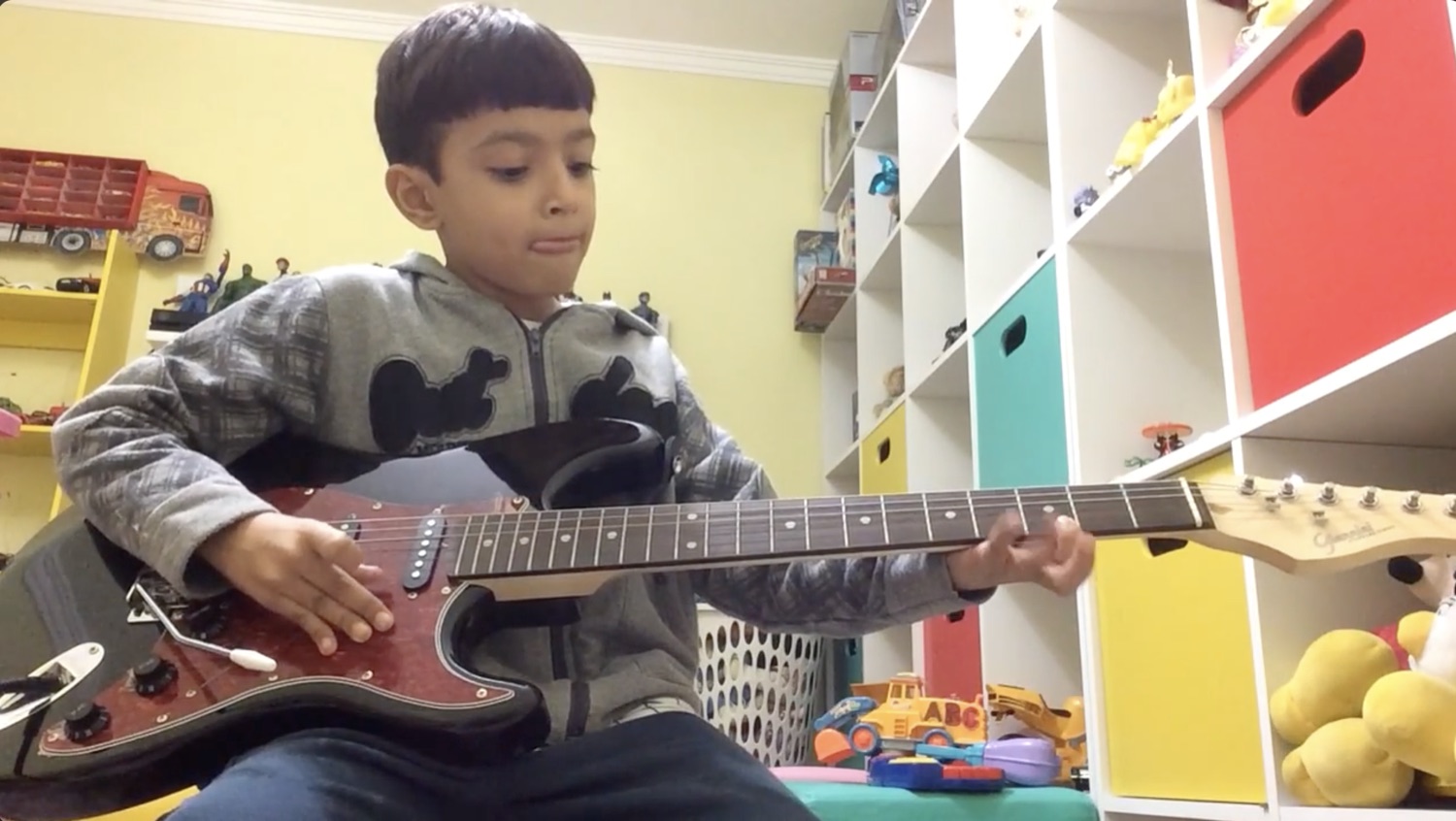 Diego playing electric guitar as a child