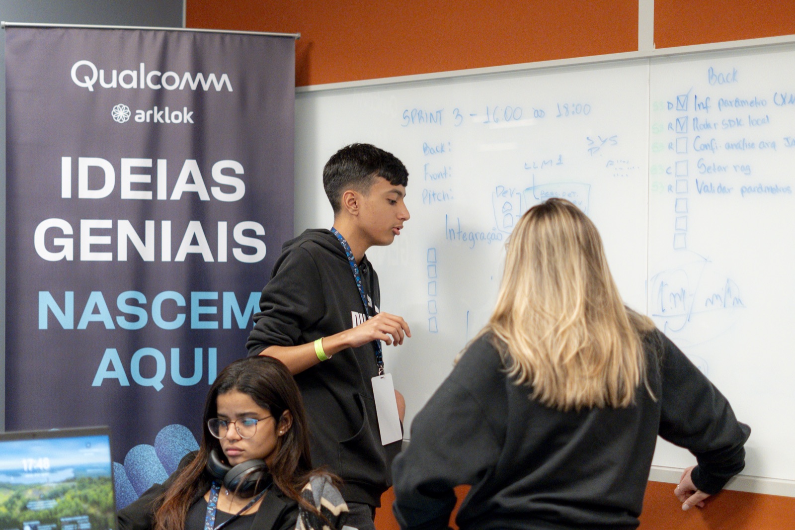 Diego and teammates presenting work on a whiteboard at a Qualcomm hackathon