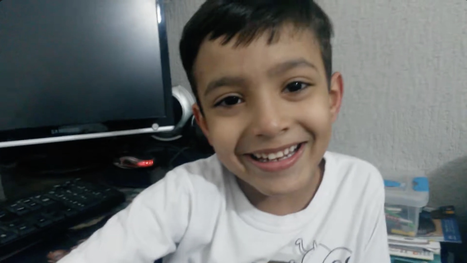Diego as a child beside a desktop computer
