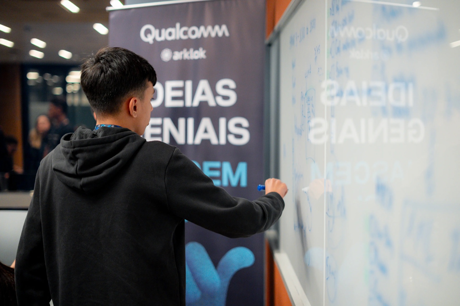 Diego developing calculations on a glass board during a technical event